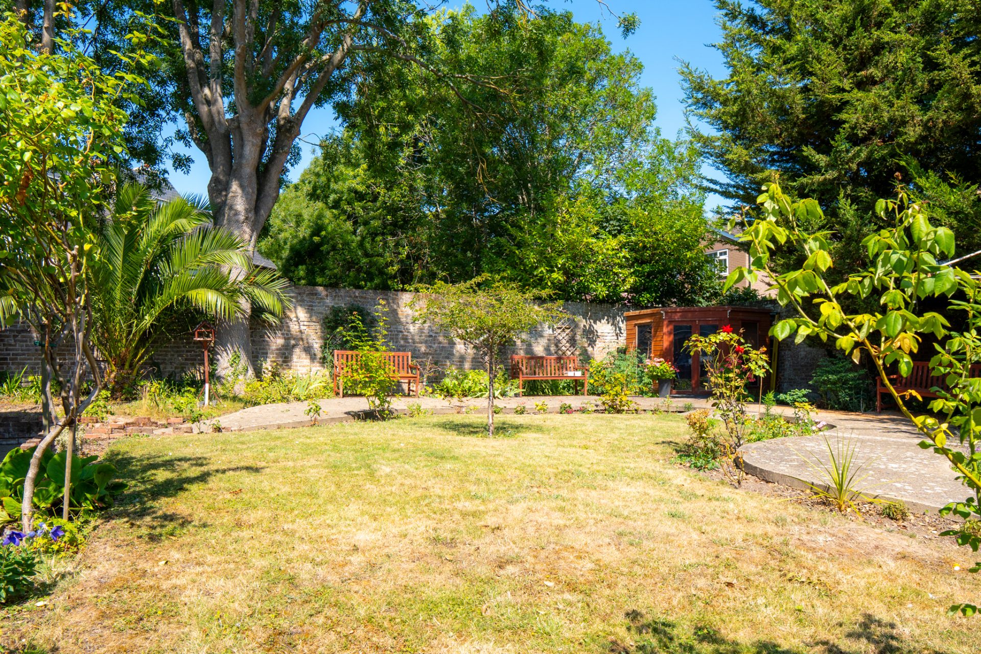 Large garden lawn with trees and seating